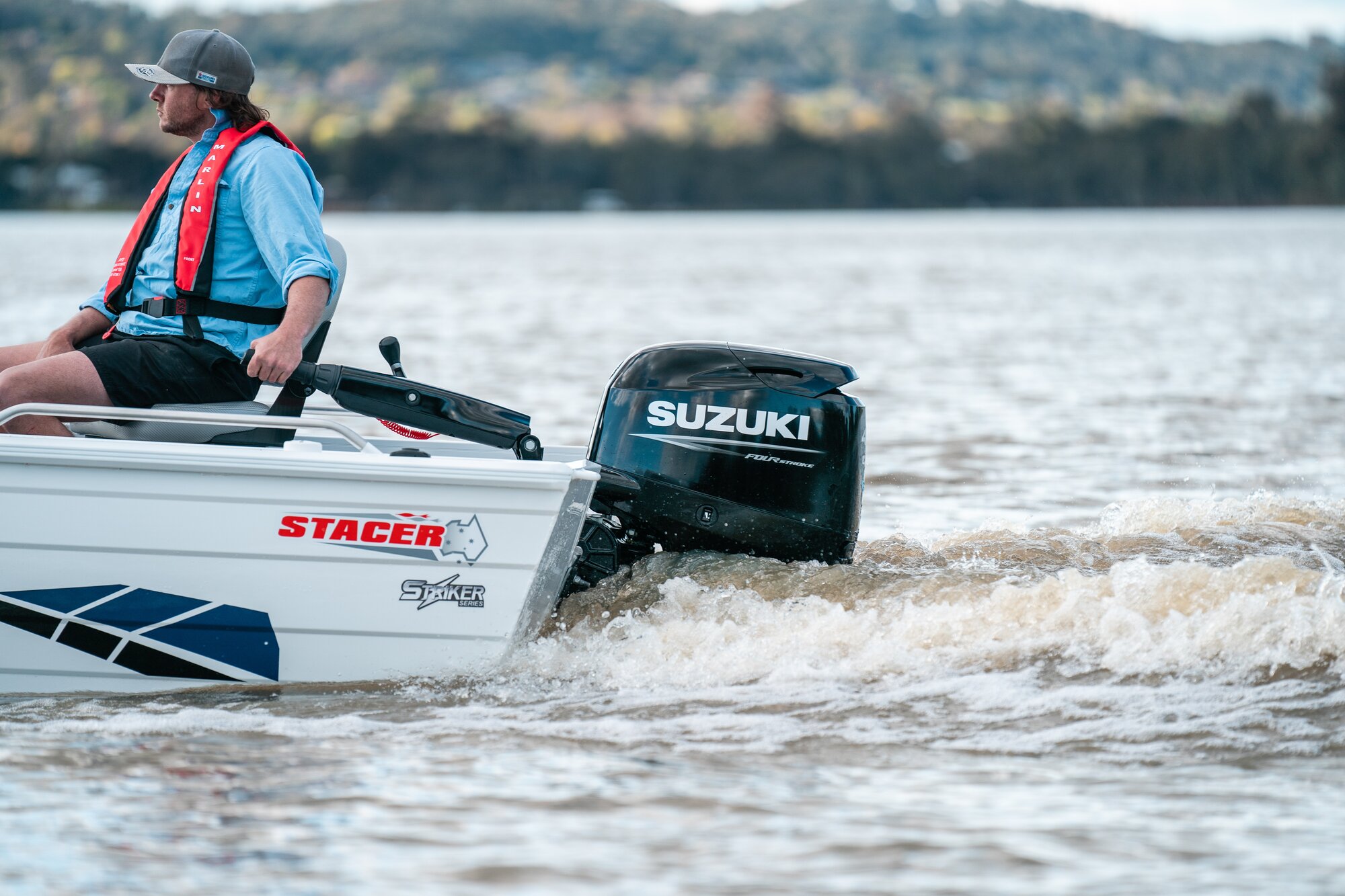 Mann auf Boot mit Suzuki Motor 