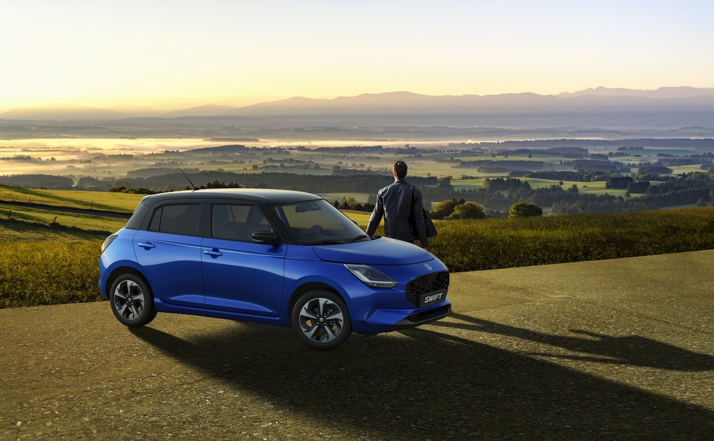 Suzuki Swift et un homme, avec un beau paysage en arrière-plan