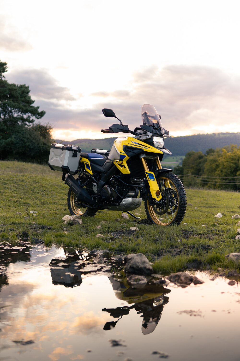 Suzuki V Strom 1050DE Mann steht neben V Strom 1050DE und schaut in Sonne