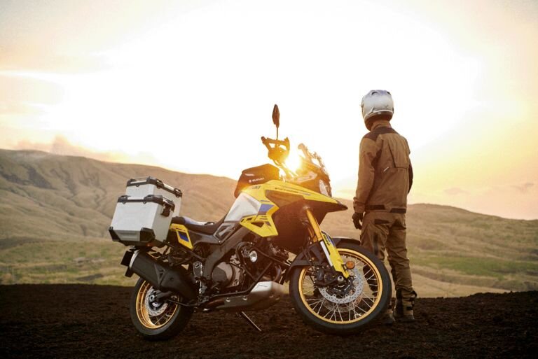Suzuki V Strom 1050DE Mann steht neben V Strom 1050DE und schaut in Sonne