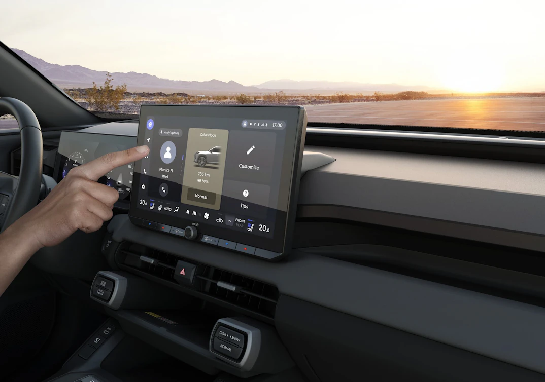 Ein weisser Suzuki Across am Laden, im Hintergrund ein modernes Haus am Meer