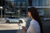 Zeekr im Hintergrund, Frau mit Handy im Vodergrund