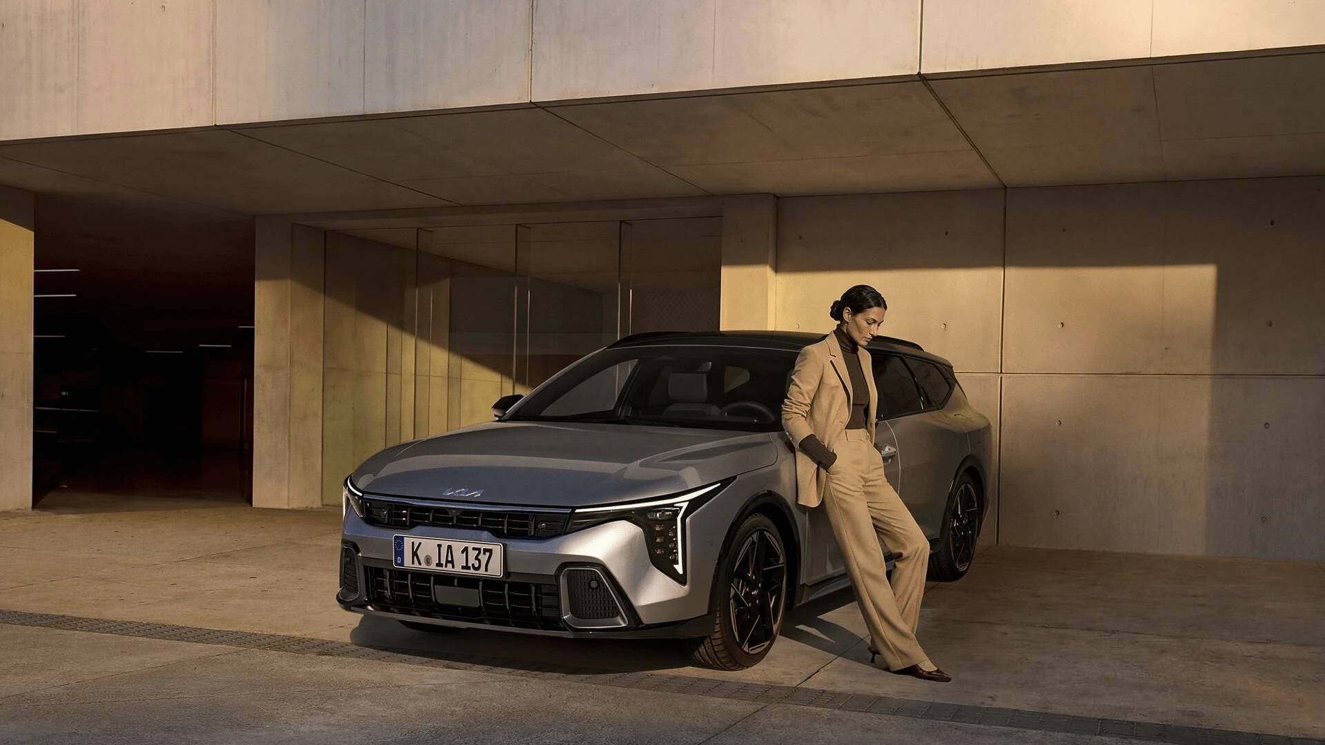 Eine Frau lehnt an den KIA K4 Sportswagon