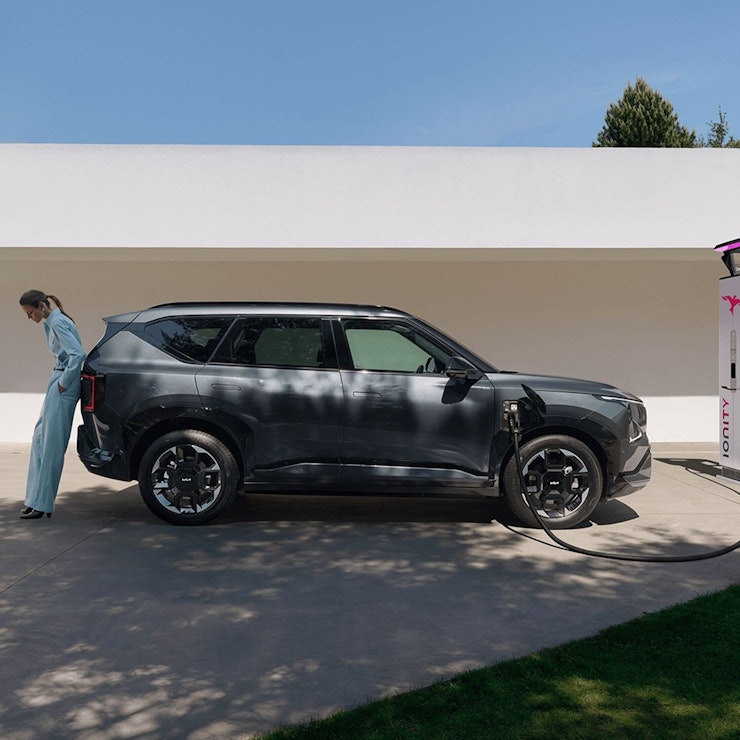 Eine Frau lädt ihren Kia EV5 in der Öffentlichkeit