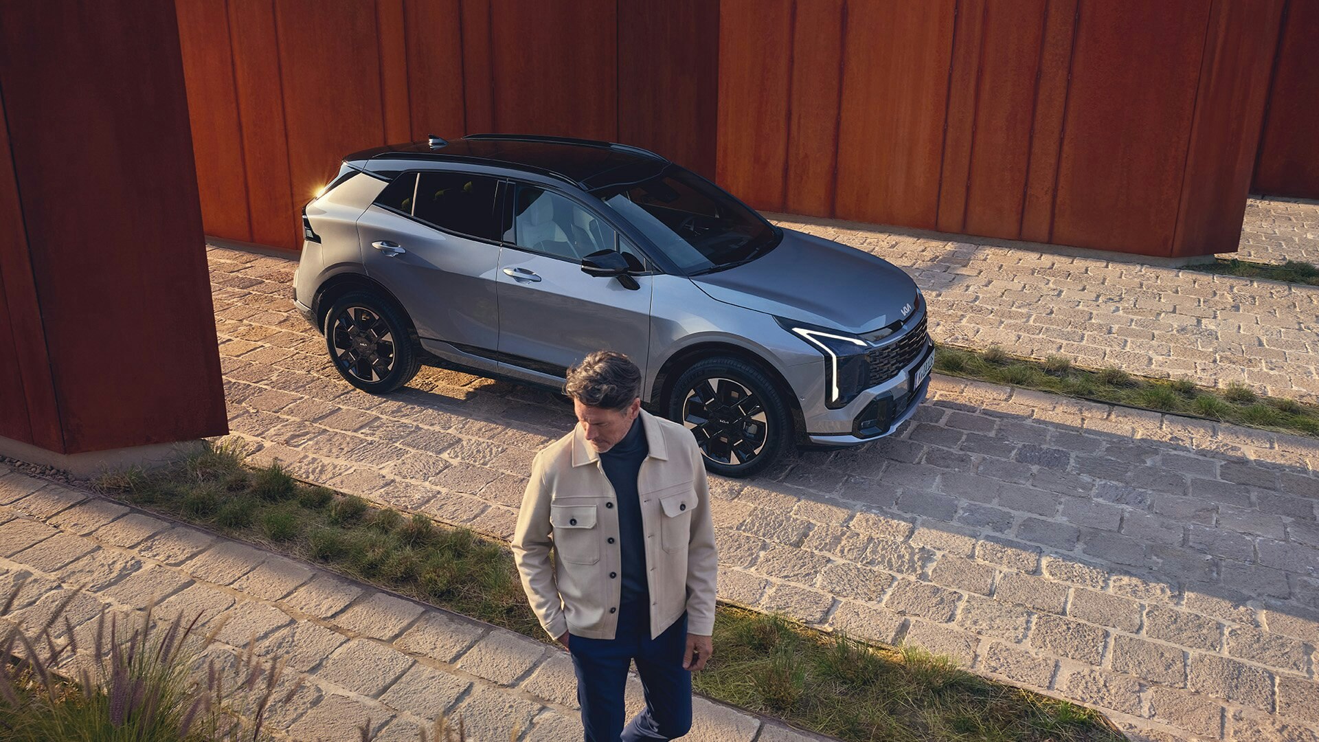 Ein Mann steht vor dem neuen Kia Sportage
