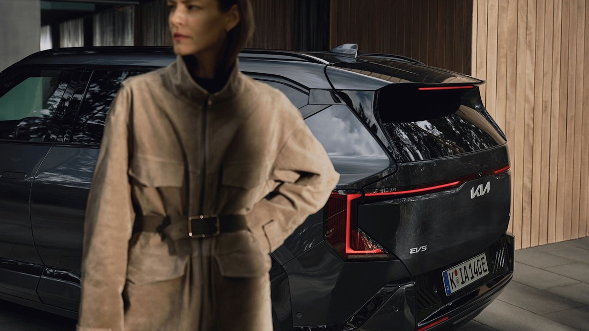 Eine Frau steht vor dem Kia EV5