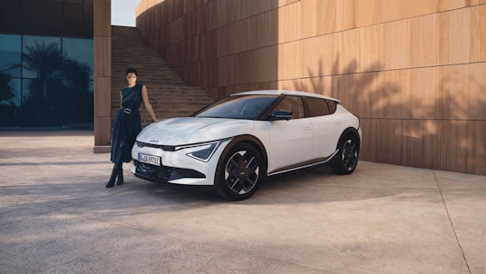 Une femme se tient devant la Kia EV6