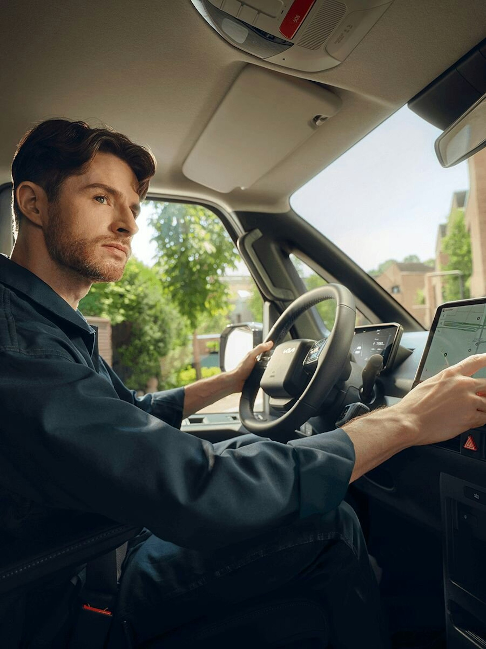 Frontansicht des Kia PV5 Passenger, parkiert in einer modernen Wohngegend, wobei das klare und geometrische Aussendesign hervorgehoben wird