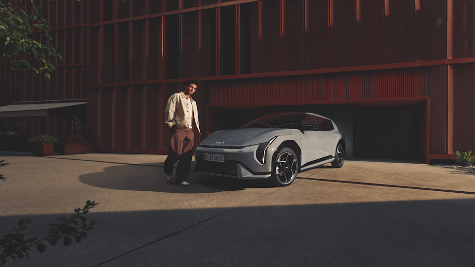 Ein Mann steht vor dem New Kia EV4