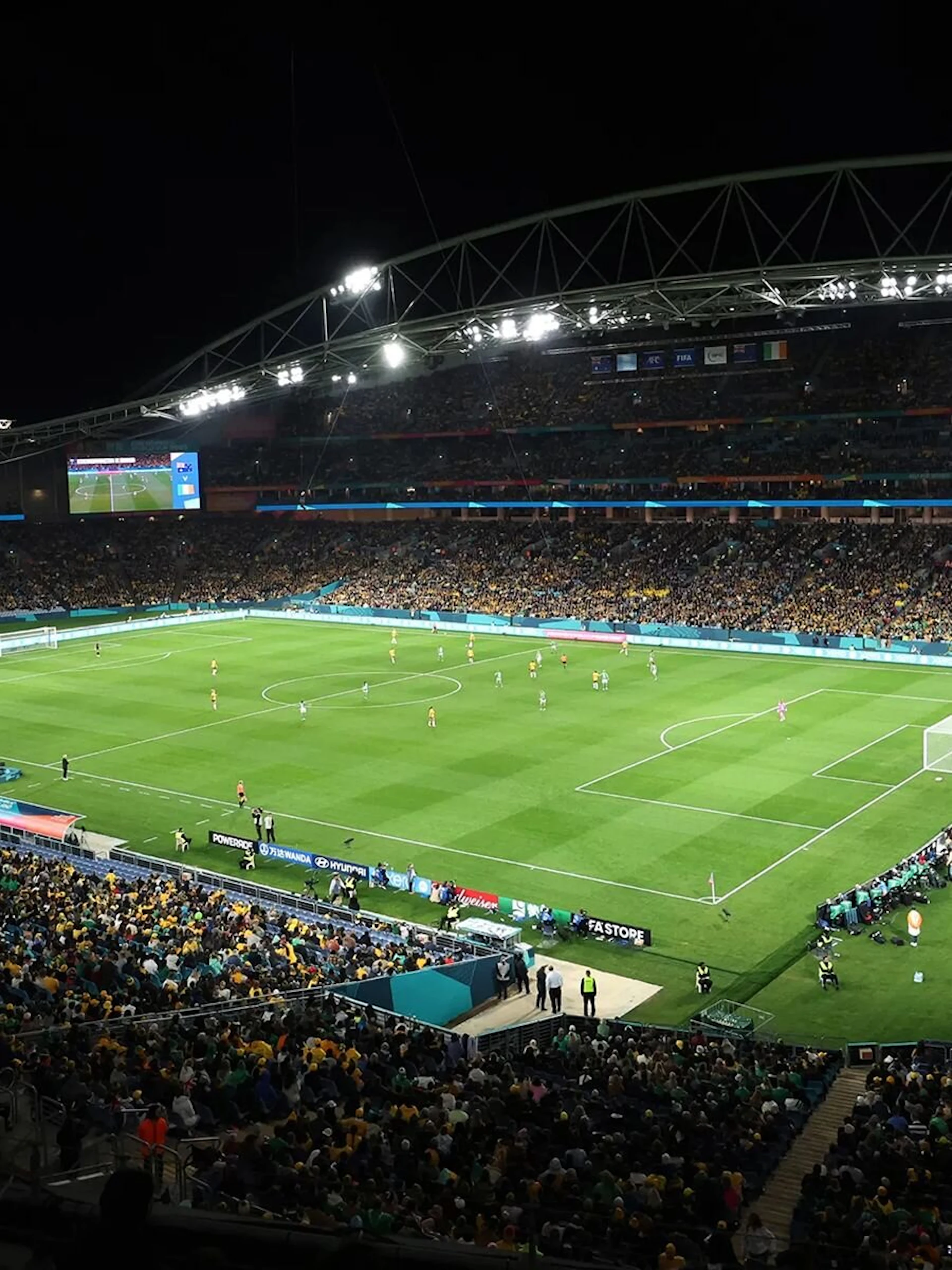Fussballstadion bei Flutlicht mit vollen Rängen