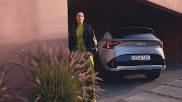Eine Frau steht neben dem Heck des New Kia Sportage