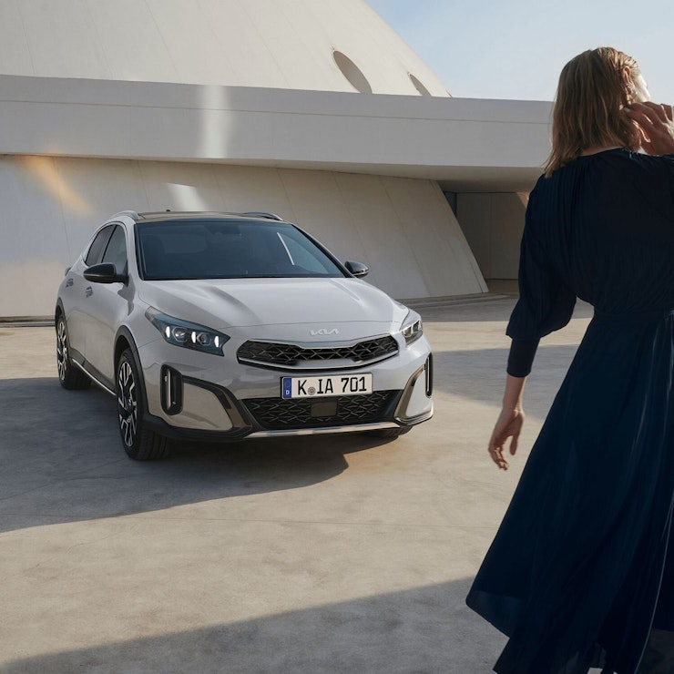 Eine Frau lehnt sich an den Kia XCeed