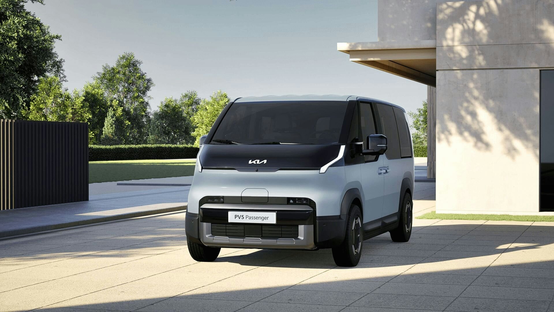 Frontansicht des Kia PV5 Passenger, parkiert in einer modernen Wohngegend, wobei das klare und geometrische Aussendesign hervorgehoben wird