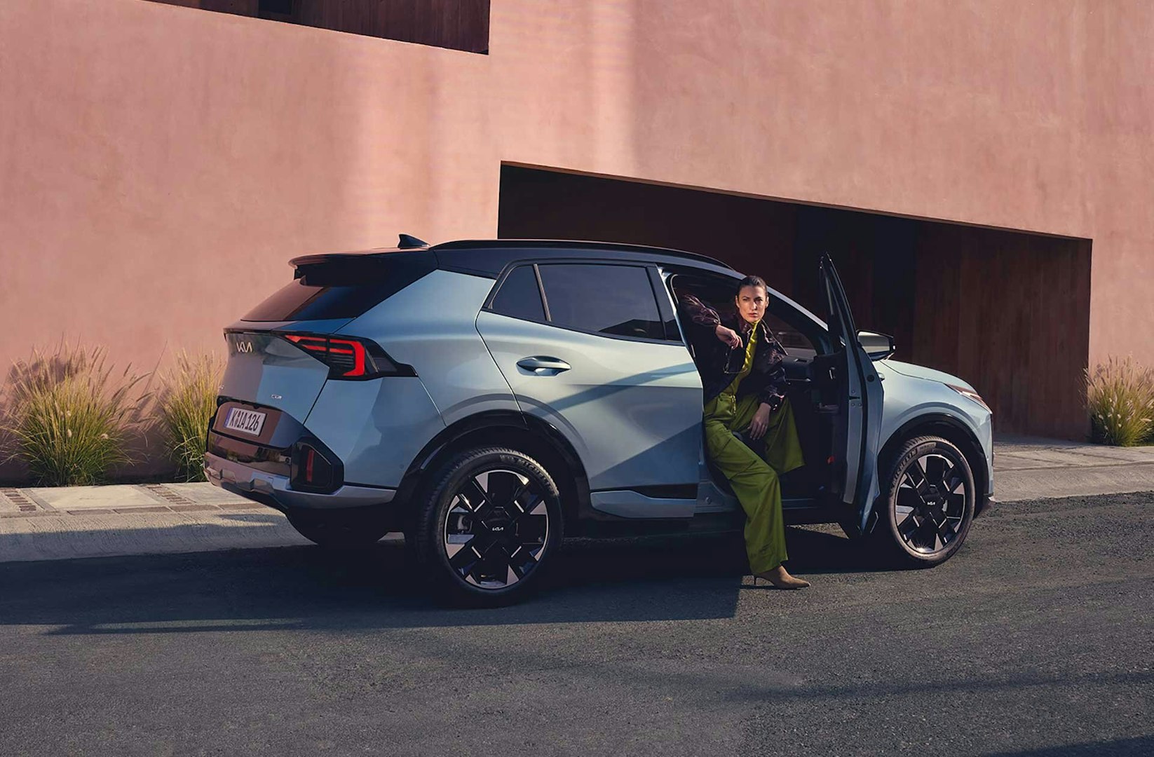 Eine Frau steigt aus dem neuen Kia Sportage
