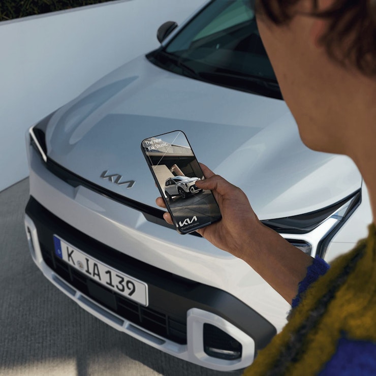 Eine Person bedient Kia Connect vor dem neuen Stonic