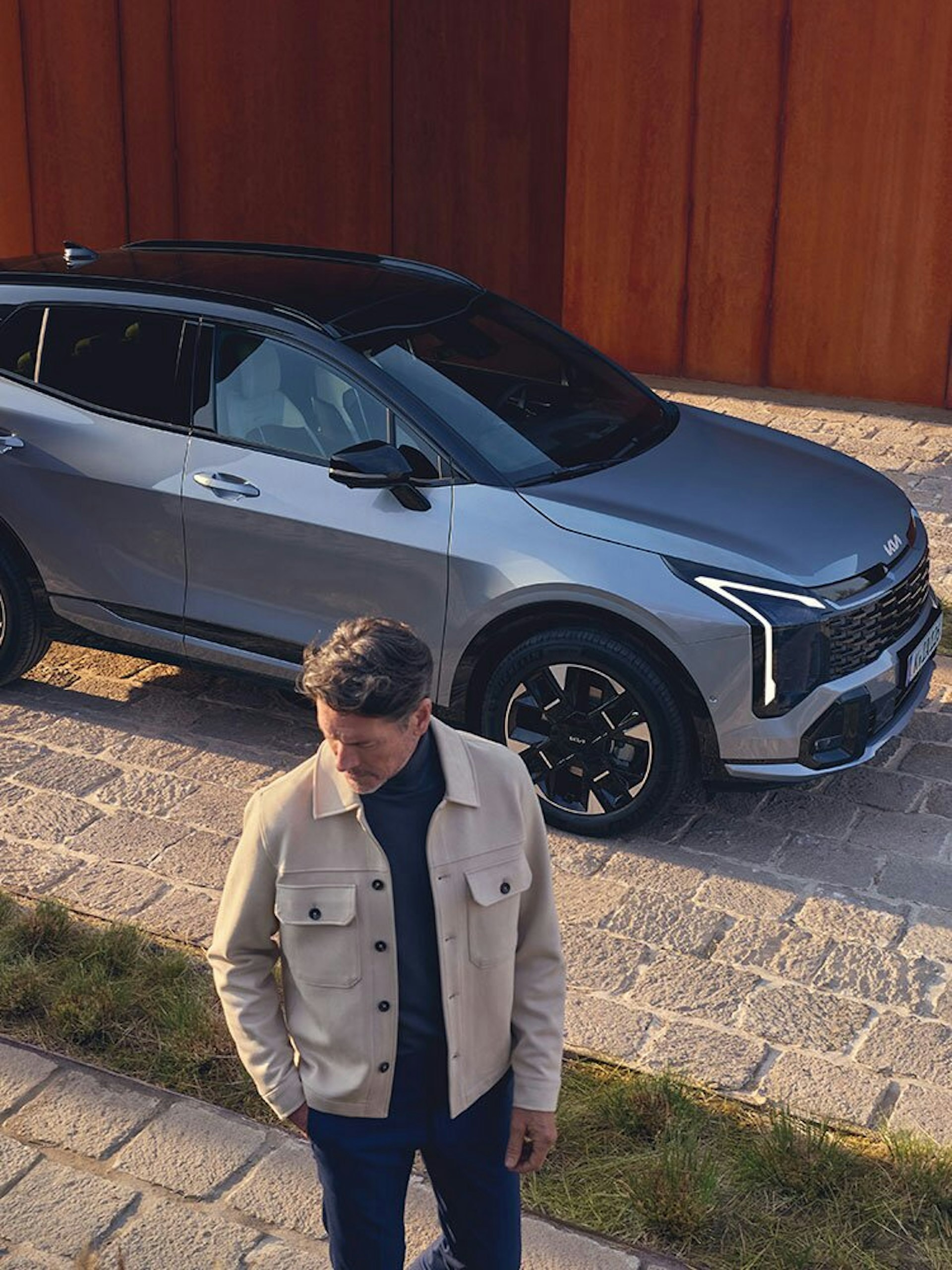 Ein Mann steht vor dem neuen Kia Sportage