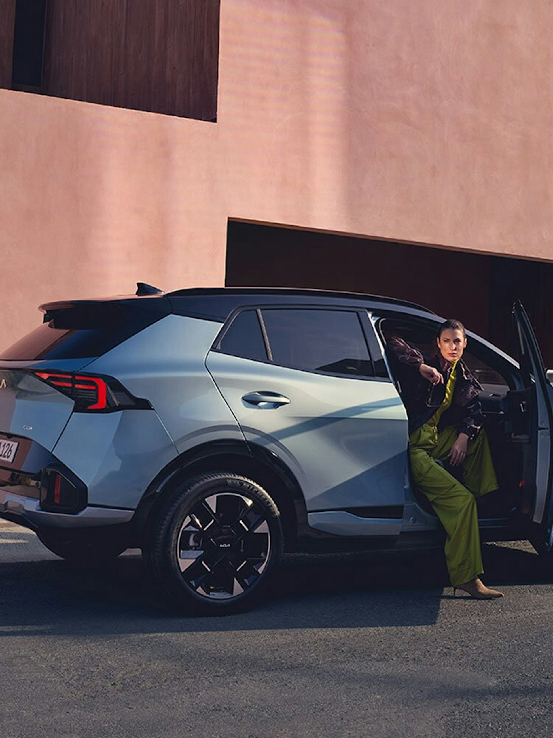 Eine Frau steigt aus dem neuen Kia Sportage