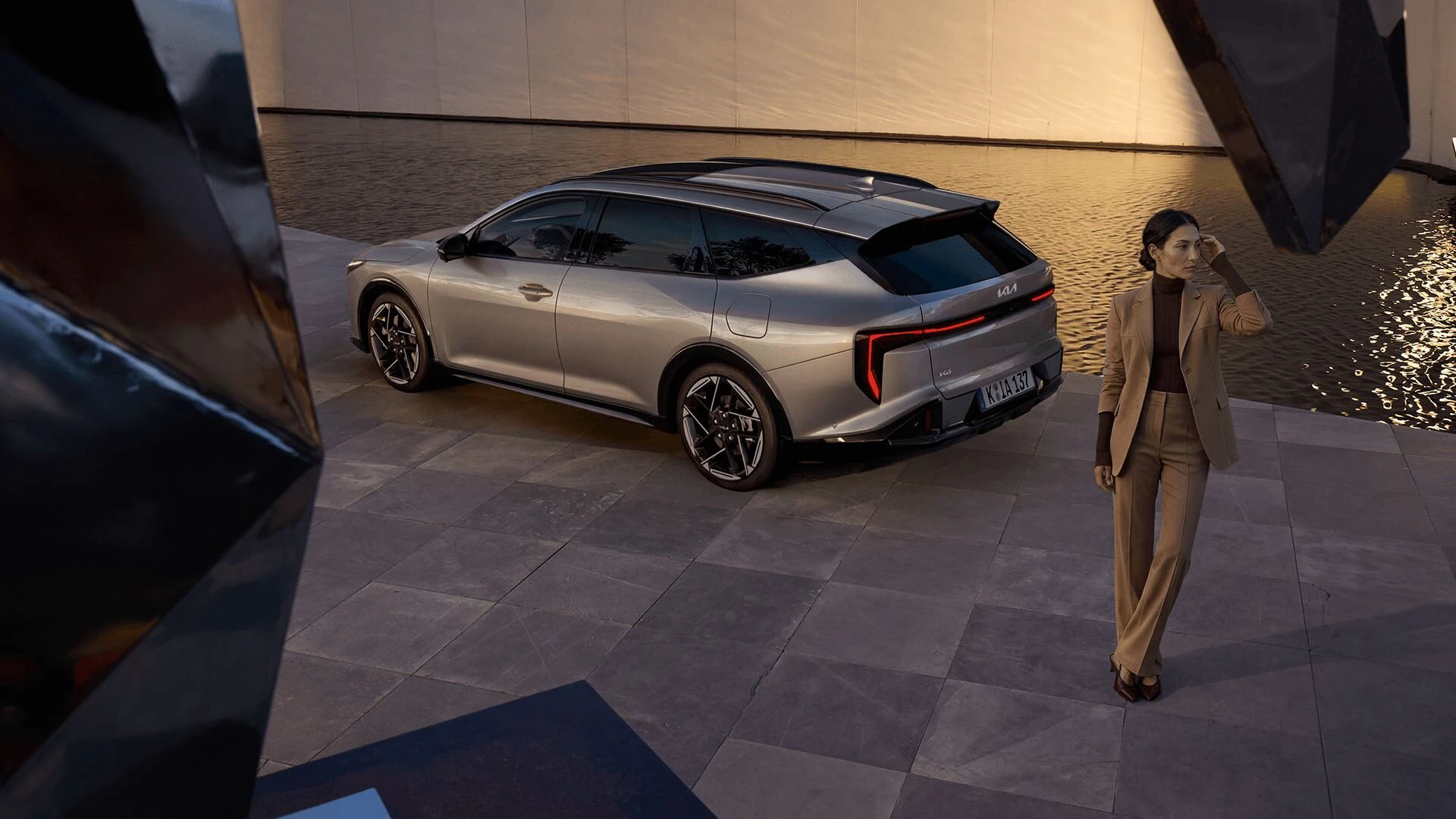 Eine Frau steht hinter dem Kia K4 Sportswagon