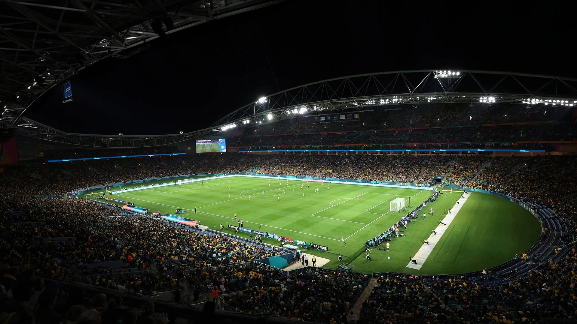 Fussballstadion bei Flutlicht mit vollen Rängen