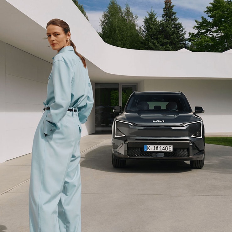 Eine Frau steht vor dem Kia EV5