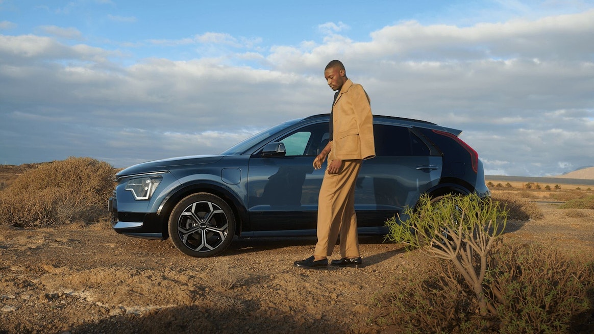 Eine Frau steht beim Kia Niro