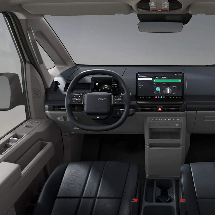 Innenansicht vorne des Kia PV5 Passenger mit breiter Windschutzscheibe, beheizbarem Lenkrad und strapazierfähigen Sitzbezügen für den täglichen Gebrauch