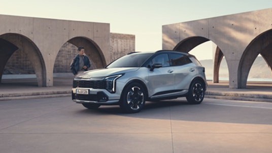 Ein Mann steht nebem dem Kia Sportage