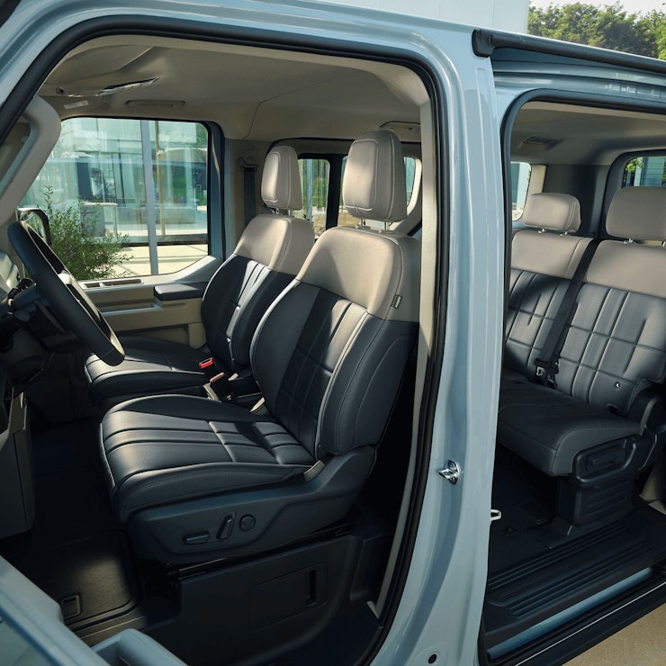 Innenraum auf der Fahrerseite des Kia PV5 Passenger mit USB-C-Anschlüssen für schnelles Aufladen sowie klimatisierten Sitzen mit Heiz- und Kühlfunktion